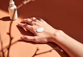 Hands applying a skincare cream